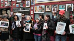 ناشطون يحملون صور معتقلين ومفقودين أمام حافلة لندن - جيتي