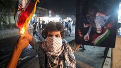 متظاهر عراقي يحرق العلم الإيراني بعد اقتحام القنصلية في البصرة- جيتي