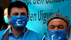 ناشطون من الإويغور يرتدون أقنعة الوجه مع علم تركستان الشرقية 2020 خارج وزارة الخارحية برلين جيتي