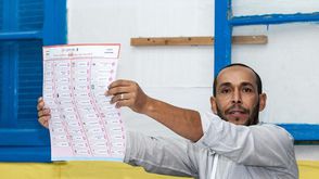 عضو بلجنة فرز يرفع ورقة الانتخاب - الأناضول