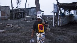 رجل يترك منزله في المكسيك قبل وصول الإعصار باتريسيا - أ ف ب إعصار