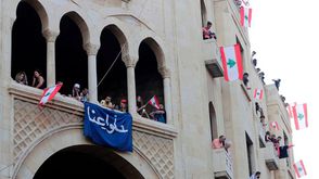 لبنانيون يرفعون لافتة كتب عليها عنا (اغربو عنا)- خلال تظاهرة مركزية ببيروت- جيتي