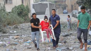 فلسطينيون ينقلون طفلة معاقة هربا بعد تدمير منزلها- جيتي