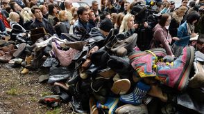 مصابون بفيروس الايدز يحملون مئات الأحذية لاشخاص أودى بهم بتظاهرة في سويسرا - ا ف ب
