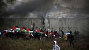 فلسطينيون خلال مواجهات مع قوات الاحتلال قرب الجدار الفاصل- جيتي
