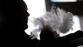 رجل يدخن سيجارة الكترونية في ميامي بفلوريدا في 20 شباط/فبراير 2014
