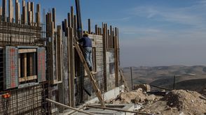 عامل فلسطيني يبني منزلا في مستوطنة إسرائيلية في الضفة الغربية
