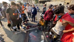 متظاهرون أمام آثار دماء زميل لهم سقط برصاص الأمن صباح اليوم- الأناضول