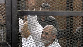 مرشد الإخوان محمد بديع يرفع شعار رابعة جلسة محاكمة 11-12-2013