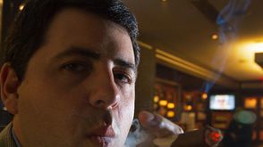 اميركي يدخن سيجارا داخل متجر كورتيس درابر الذي يعد من اعرق متاجر التبغ الاميركية