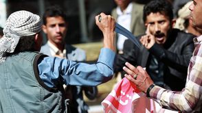 أحد عناصر الحوثي يعتدي على المتظاهرين بالسلاح الأبيض - أ ف ب