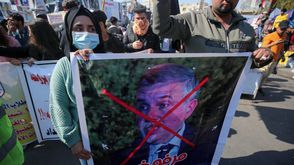 متظاهرون في بغداد يحملون صورة لمحمد علاوي "مرفوض" خلال مظاهرة مناهضة للحكومة الثلاثاء - أ ف ب