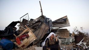 فلسطينية تجلس قرب بيتها المدمر في العراقيب