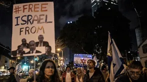 إسرائيلية ترفع صورة أعضاء حكومة نتنياهو على لافتة تقول حرروا إسرائيل من هؤلاء- الأناضول