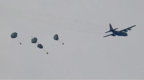 لحظة إلقاء طائرة عسكرية أردنية مساعدات بالمظلات فوق قطاع غزة- جيتي