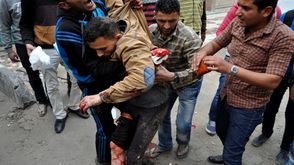 مصريون يسعفون شخصا إثر مهاجمتهم من قبل الشرطة المصرية (أرشيفية) ا ف ب