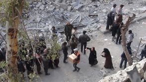 لاجئون بمخيم اليرموك يحاولون الحصول على بعض المساعدات - ا ف ب