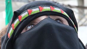 امرأة فلسطينية خلال عرض لكتائب القسام (عربي21)