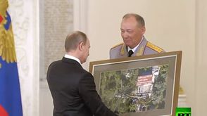 بوتين يتسلم صورة هدية من جيشه في سوريا سبوتنيك