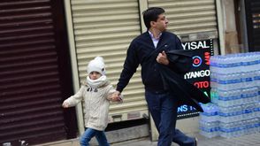 رجل يهرب مع طفلته المذعورة من موقع الهجوم الانتحاري- أ ف ب