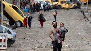 أب وابنته يهربان من منطقة يسيطر  عليها تنظيم الدولة من الموصل باتجاه القوات العراقية - رويترز