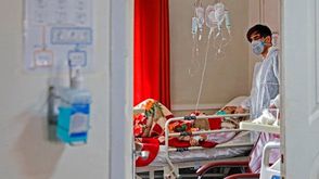 طبيب إيراني يعالج مريضا مصابًا بفيروس كورونا في أحد مستشفيات طهران - جيتي