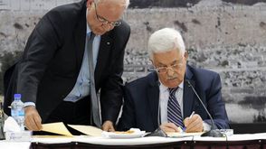 عباس وعريقات خلال التوقيع على وثائق الانضمام للمنظمات الدولية - ا ف ب