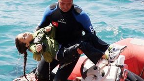 غطاس من خفر السواحل التركية يخرج جثة طفلة حاولت الهجرة - (أرشيفية) أ ف ب