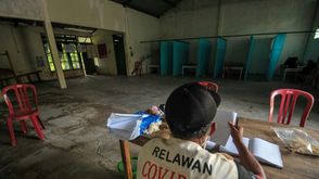 متطوع يشرف على مركز للعزل في منزل شاغر يعتبره البعض مسكونا في قرية سيبات الإندونيسية في 21 نيسان/أبر