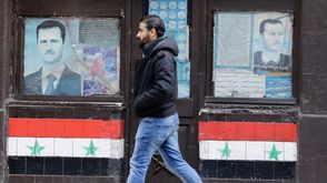 سوريا  رجل يمشي بجانب صورة بشار الأسد في دمشق - أ ف ب