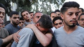 شاب فلسطيني يبكي شقيقه الذي استشهد في مجزرة غزة - جيتي