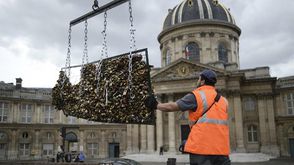 عامل يزيل "اقفال الحب" التي كانت معلقة على جسر بون ديزار الشهير في باريس، الاثنين 1 حزيران/يونيو 201