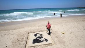 فلسطيني يرسم صورة "أردوغان" على شاطئ بحر غزة - الأناضول