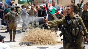 جندي احتلال يعتدي على فلسطينيين- وفا