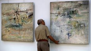 صورة التقطت في 28 أيار/مايو 2023 يبدو فيها رجل أمام لوحة "الموت للاستعمار" للفنان العراقي شاكر حسن ال سعيد في المتحف الوطني للفن الحديث في بغداد