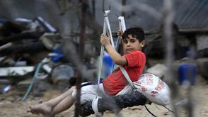 طفل فلسطيني على أرجوحة في مخيم للاجئين في غزة - جيتي