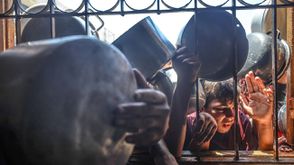 أطفال من غزة ينتظرون أمام مطبخ خيري للحصول على القليل من الطعام- جيتي