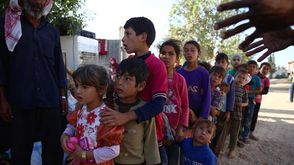 أطفال سوريون يصفون لتلقي المساعدات - أ ف ب