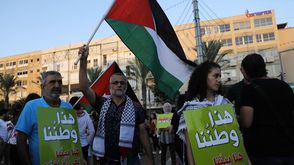 ناشط من فلسطينيي الداخل يرفع العلم الفلسطيني في تل أبيب- جيتي