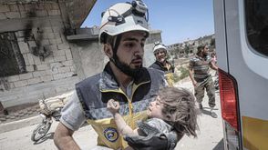 عامل إنقاذ ينقذ طفلا من تحت الأنقاض في منطقة أريحا في إدلب - جيتي