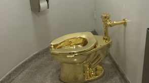 مرحاض مصنوع من الذهب الخالص من تصميم الفنان الايطالي ماوريتزيو كاتيلان في متحف غوغينهايم في نيويورك