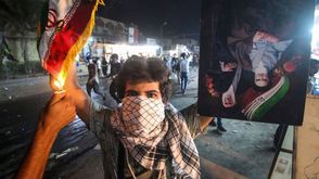 متظاهر عراقي يحرق العلم الإيراني بعد اقتحام القنصلية في البصرة- جيتي