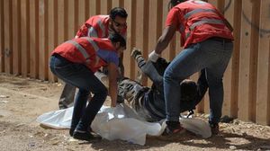 عناصر الهلال الأحمر يخلون جثثا في بنغازي وسط احتدام المعارك - أ ف ب