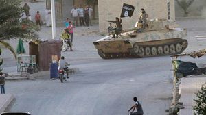 مقاتلو "تنظيم الدولة" يعتلون دبابة ويسيرون بأحد شوارع كوباني السورية  - أرشيفية