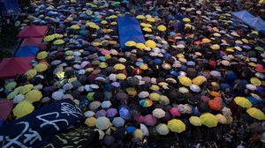 الناشطون الصينيون يحملون المظلات رمز تحركهم - أ ف ب