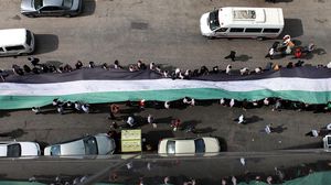 طلبة مدارس يحملون علم فلسطين في رام الله - الأناضول