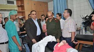 محافظ حمص وقائد الشرطة بالمدينة أثناء تفقد جرحى تفجير المدرسة - فيسبوك