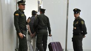 عناصر من شعبة مكافحة المخدرات في الشرطة الكولومبية يوقفون مسافرا في مطار بوغوتا - أ ف ب
