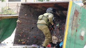 جندي إسرائيلي يختبئ خلف "حاوية القمامة" خشية إصابته بحجارة الفلسطينيين - تويتر