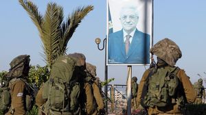 جنود إسرائيليون أمام صورة عباس خلال اقتحام بلدة بالضفة- أرشيفية
